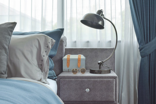 Industrial style reading lamp next to blue color scheme bedding