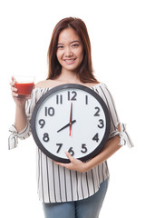 Young Asian woman with tomato juice and clock.