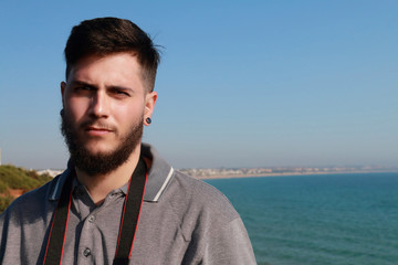 Young and handsome man with beard posing in front of camera