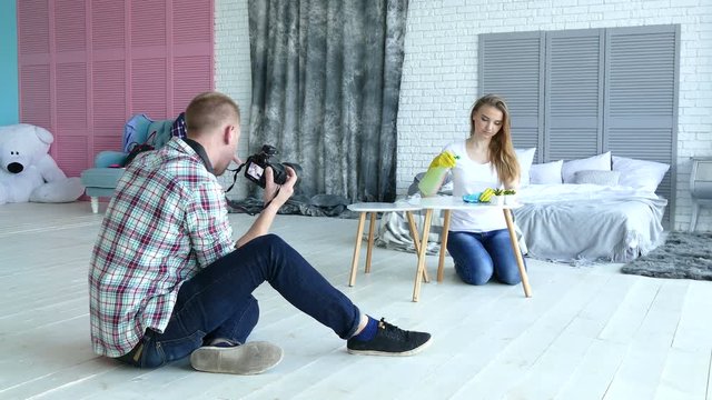 
 Photoshooting  studio backstage . Man photographer work with model like housewife. 
