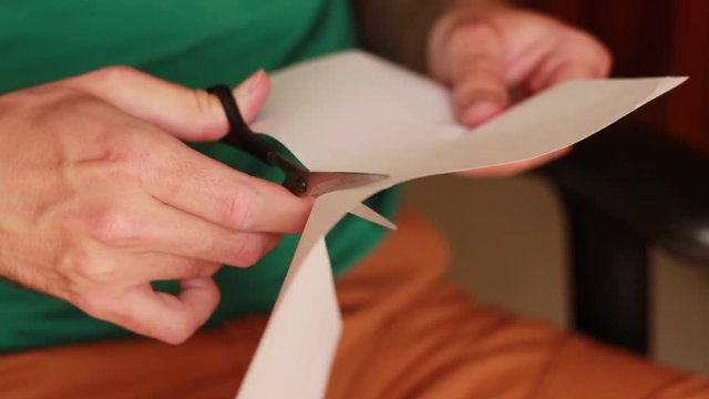 Scissors cutting a sheet of paper