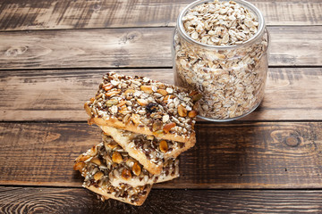 Baked oats with dry fruits, a jar with oats on wooden table
