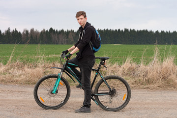 Young man on mountain bike on spring trip.