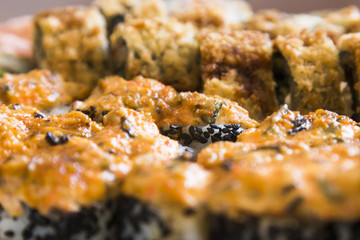 Sushi rolls with salmon, black caviar and sesame close-up macro shot