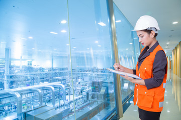 Business woman taking notes in production area of factory
