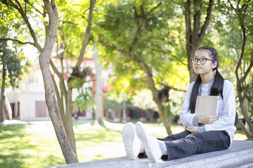 Obraz premium Young students holding her books and thinking ideas in the garden