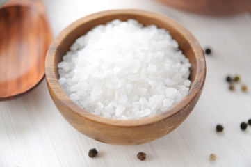 Fototapeta na wymiar Sea salt in wooden bowl on white table