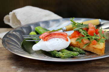Asparagus and poached egg. Toast with salad of fresh vegetables. Salty red fish