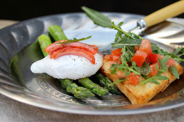 Asparagus and poached egg. Toast with salad of fresh vegetables. Salty red fish