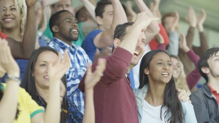  Excited sports fans at live game chanting & cheering for their team