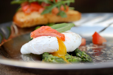 Asparagus and poached egg. Toast with salad of fresh vegetables. Salty red fish