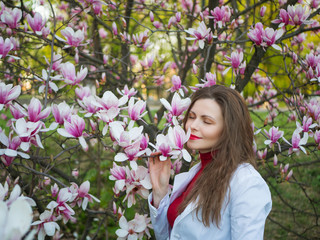 beautiful girl among magnolia pink blossom sping tree flowers
