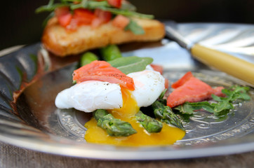 Asparagus and poached egg. Toast with salad of fresh vegetables. Salty red fish