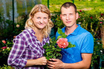 Fototapeta na wymiar Happy couple with a rose in a nursery portrait