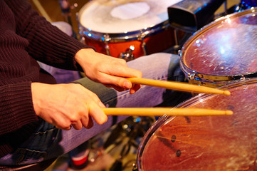 Fototapeta premium Hand of drummer with sticks and drums, close-up