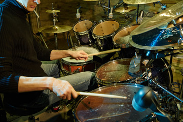 Hand of drummer with sticks and drums, close-up, Toned image