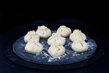 Homemade organic raw steamed Chinese bun on black slate stone plate 