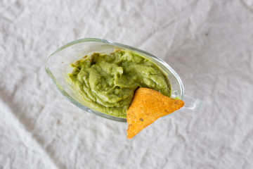 Latin American sauce guacamole and tortilla on textile background