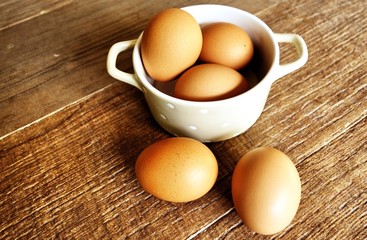 eggs in a bowl on wooden floor.