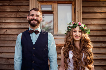 Funny bride and groom at the wooden house. Newlyweds.