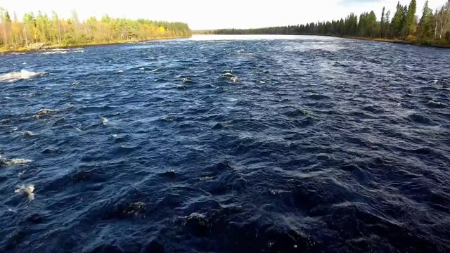 Raging blue water flow. Scandinavia in autumn. 4k resolution. raging stream of blue water