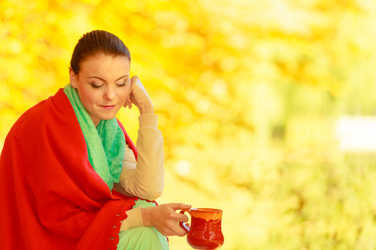 Woman relaxing in park drinking drink from mug
