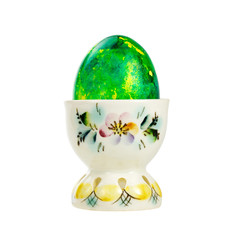 Green Easter egg in a porcelain holder isolated on white background