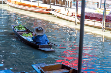 Traders are rowing boats to sell fruit at the floating market.Traditional floating market , Thailand.