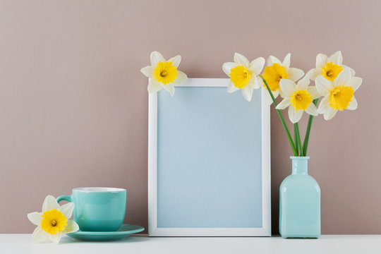 Mockup of picture frame decorated narcissus flowers in vase and coffee cup with clean space for text your blogging and greeting for mother day.