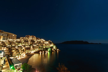 Fototapeta na wymiar Hotel complex for rich people Dukley Gardens in Budva, Montenegro. Night photo at the full moon, starry sky.