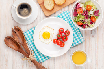 Healthy breakfast with fried egg, toasts and salad