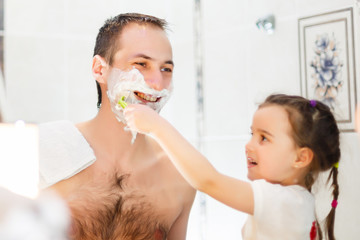 Shot of black family having fun in the bathroom with shaving foam.