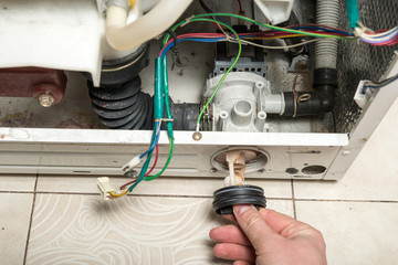 Repair old laundry washer. Opening filter-cap of the pump.