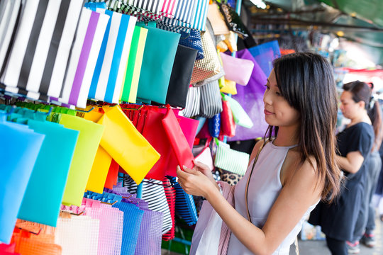 Woman choosing clutch in street market