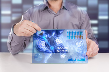 Business, Technology, Internet and network concept. Young businessman working on a virtual screen of the future and sees the inscription: Passive income