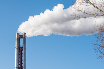 White smoke being discharged from a chimney stack.