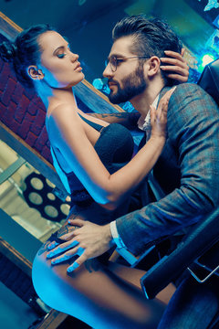 Brutal man in elegant suit and sexy girl with tattoo