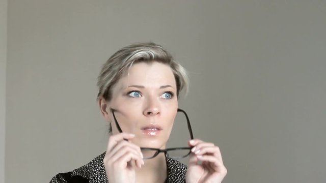 Beautiful woman with bad eyesight uses glasses