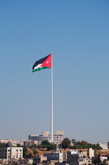 Giordania, 01/10/2013: la bandiera giordana e lo skyline di Amman visti dall'antica Cittadella, uno dei nuclei originari della città risalente al periodo romano