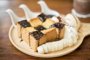 Honey toast with vanilla ice cream, whipped cream and chocolate syrup. Served with banana