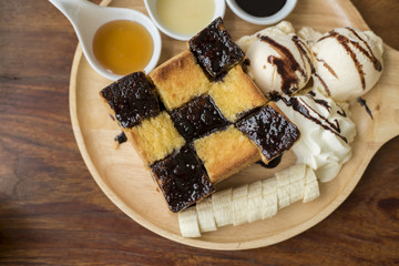 Honey toast with vanilla ice cream, whipped cream and chocolate syrup. Served with banana