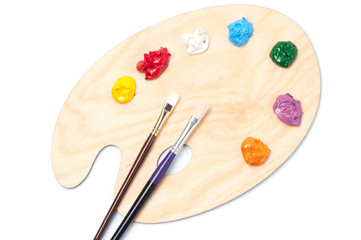 Colored artist's oil paint and brushes on the wooden palette