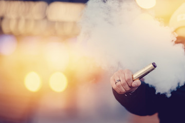 vaping man holding a mod device. cloud of vapor. Vape. high contrast and monochrome color tone.
