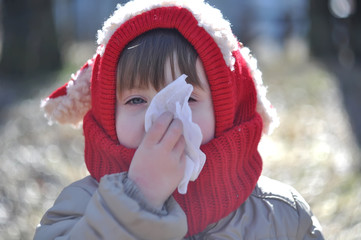 The child blows his nose in a napkin
