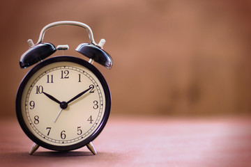 Old fashioned alarm clock with copy space on a blurred background