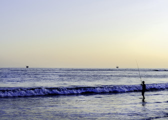 A man fishes at Refugio State Beach, Goleta, CA, USA.