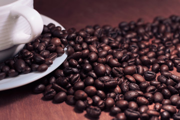 Roasted coffee beans and a white cup bright toned