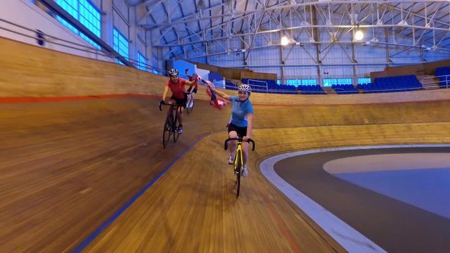  Action tracking shot of competitive cyclists on racing track in velodrome