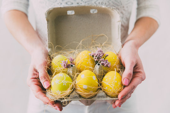 woman's Hands holding box with painted Easter eggs