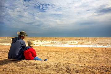 Father and son relax at sea beach